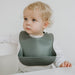 Toddler wearing Boo Chew Bib in graphite, a grey colour